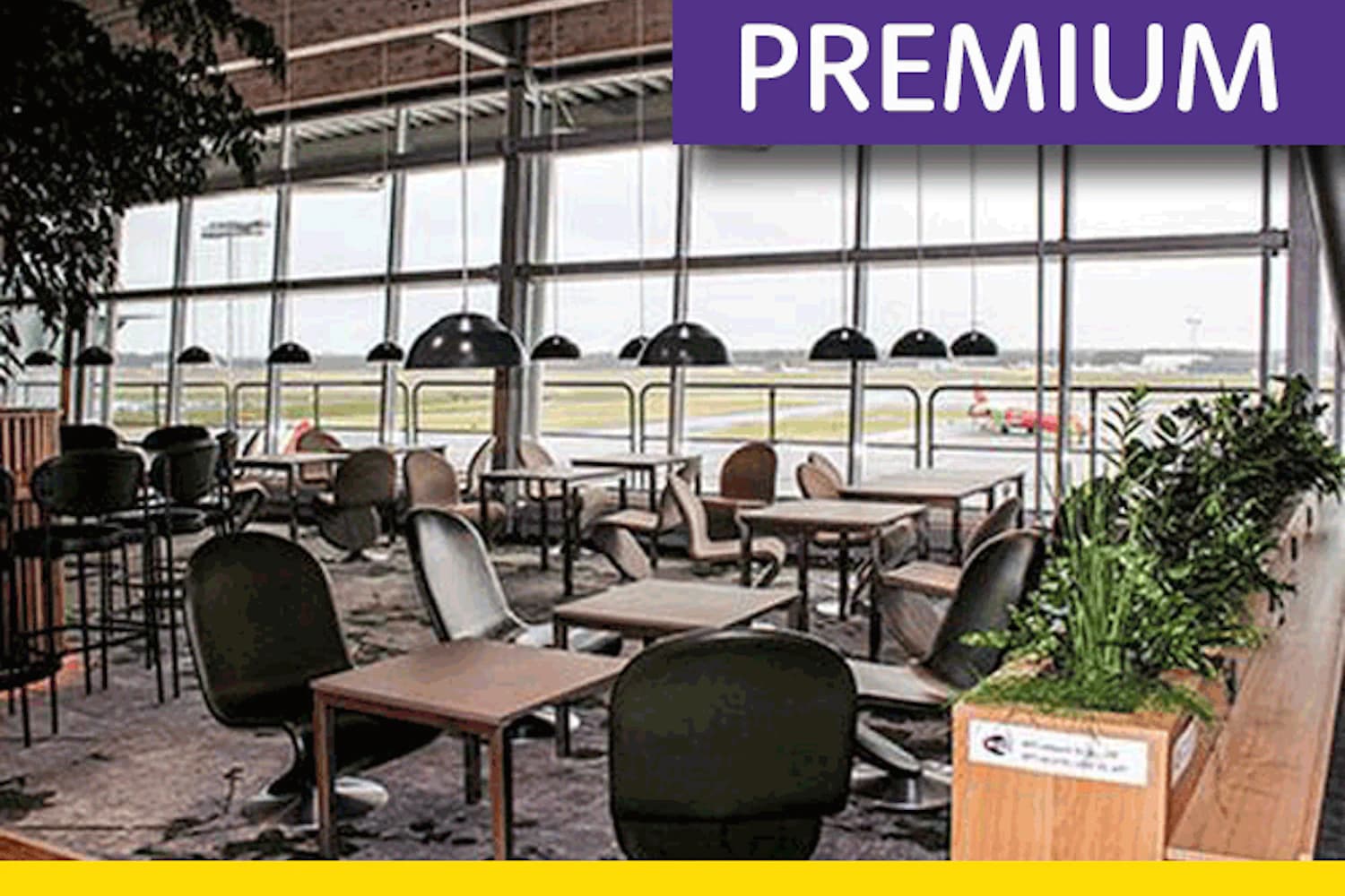 Tische und Sessel vor den Panoramafenstern zum Vorfeld in der King Amlet Lounge am Flughafen Billund