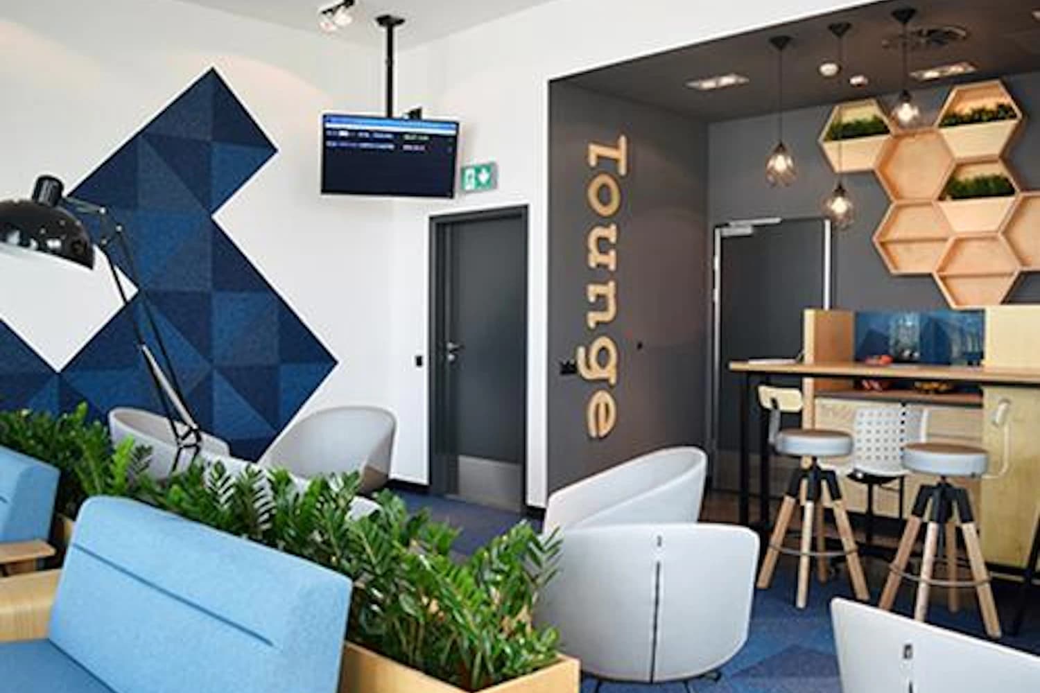 Sofas, Sessel und Holzbar mit Pflanzen in der Executive Lounge am Flughafen Bydgoszcz