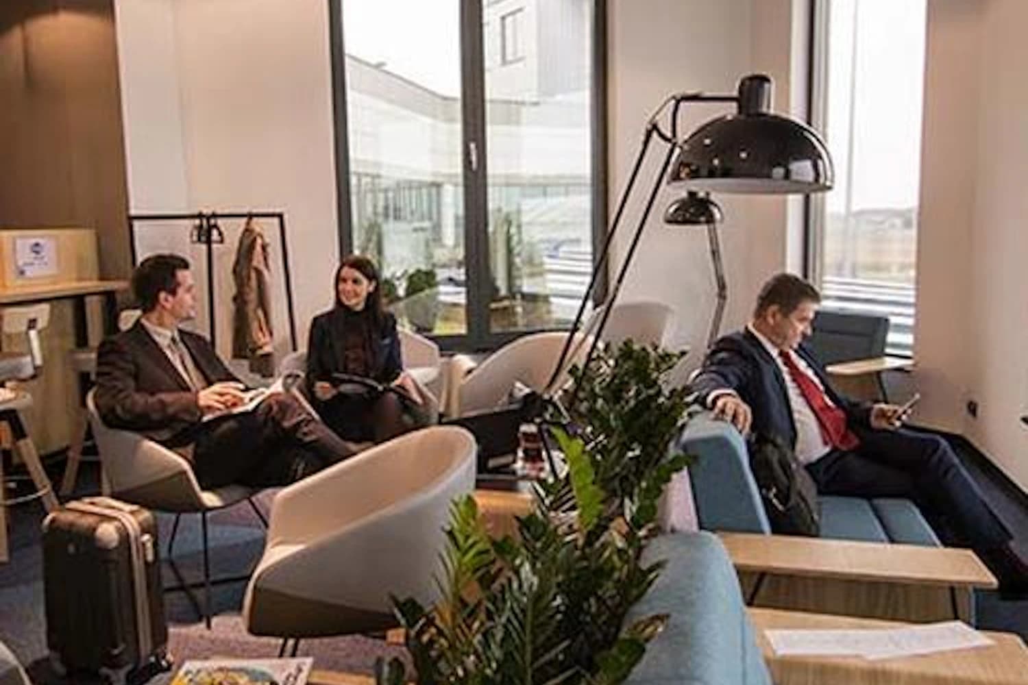 Sitzbereich mit Sofa, Sesseln und großem Fenster in der Executive Lounge am Flughafen Bydgoszcz