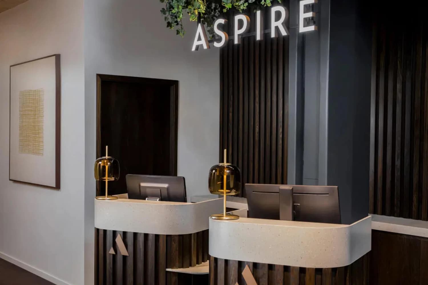 Empfangstresen mit Tischlampen und Holzlamellen in der Aspire Lounge Terminal 2 am Flughafen Kopenhagen