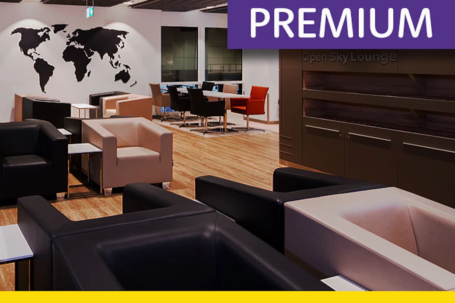 Lounge mit schwarzen und beigen Sesseln, Holzboden, Tischen und Weltkartenmotiv an der Wand.