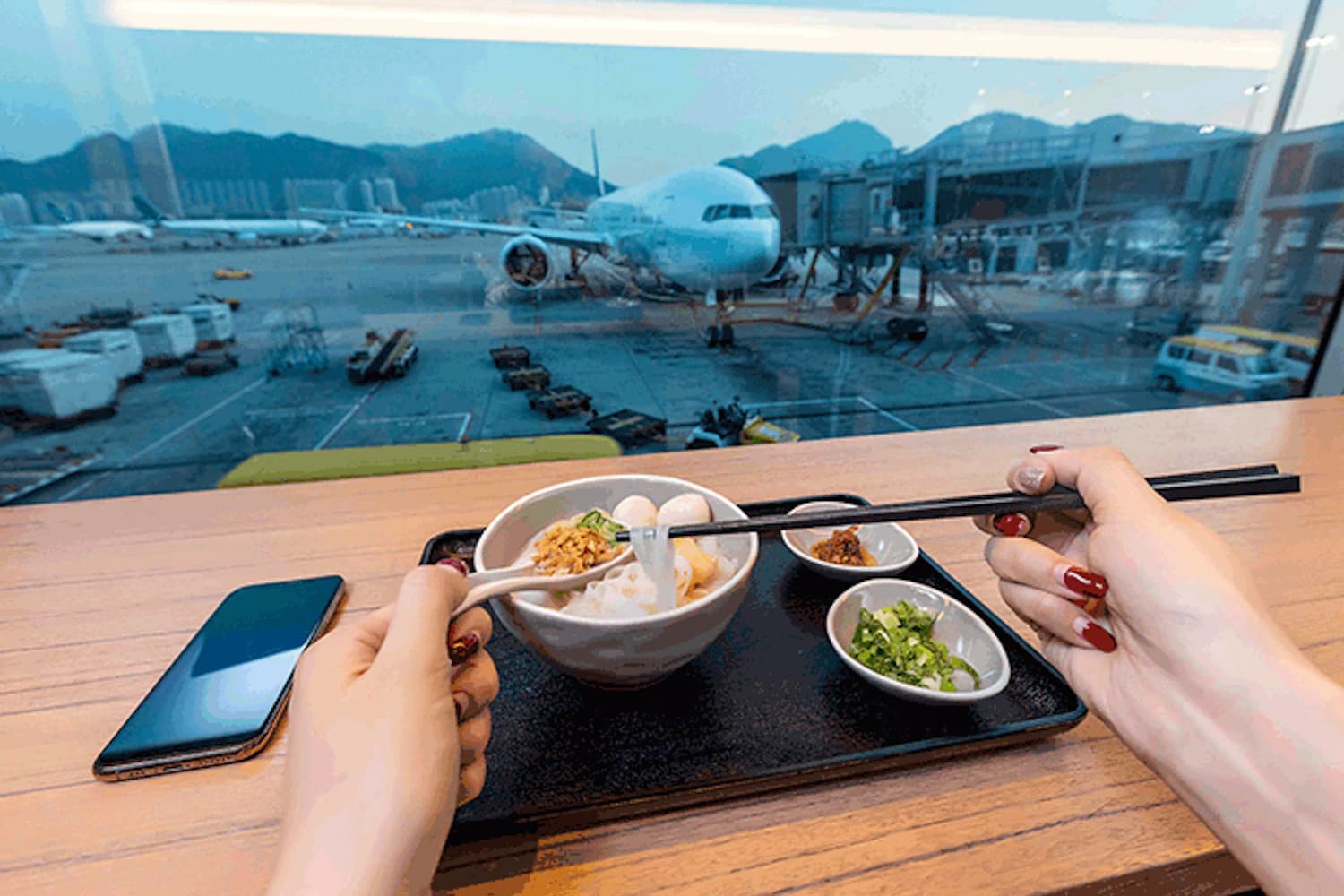 Nudelsuppe am Fensterplatz mit Blick aufs Gate in der Plaza Premium Lounge Gate 35 am Flughafen Hongkong