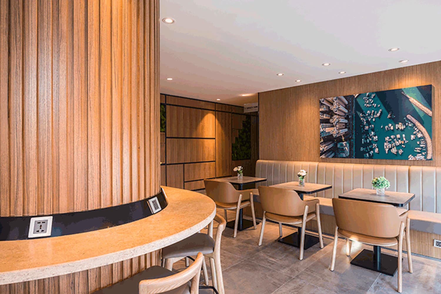 Lounge mit runder Holzsäule und Bartresen, Tische mit Lederstühlen und Wandbild einer Hafenaufnahme.