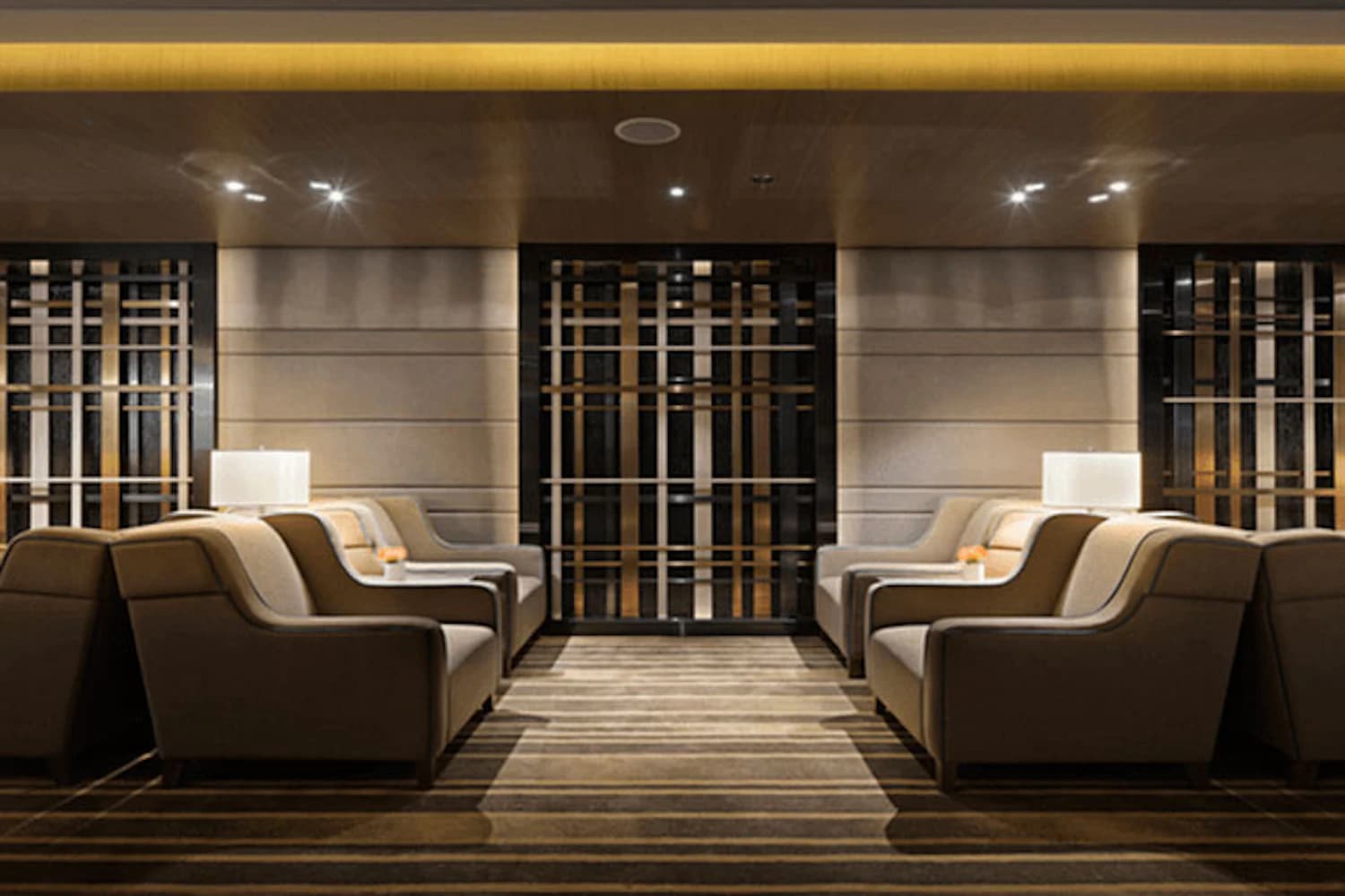 Beige Sessel und niedrige Tische in warmem Licht in der Plaza Premium Lounge Gate 35 am Flughafen Hongkong