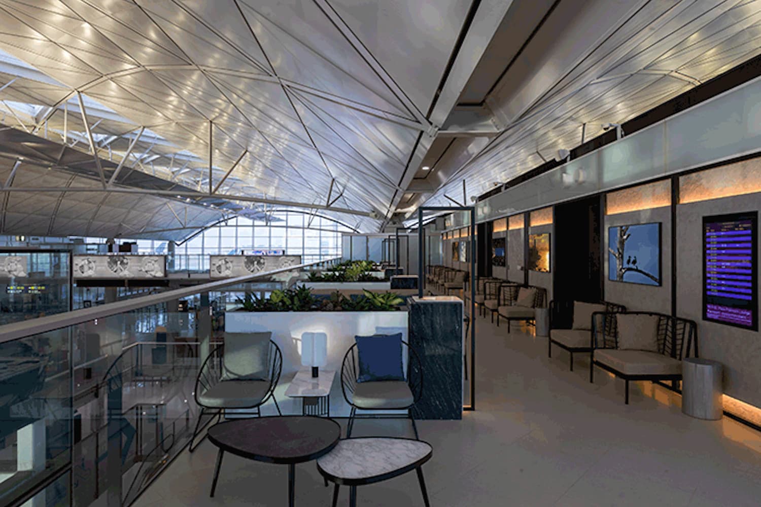 Moderner Wartebereich mit Sitzgruppen, Tischen und Blick auf das Terminal unter hohem Glasdach.