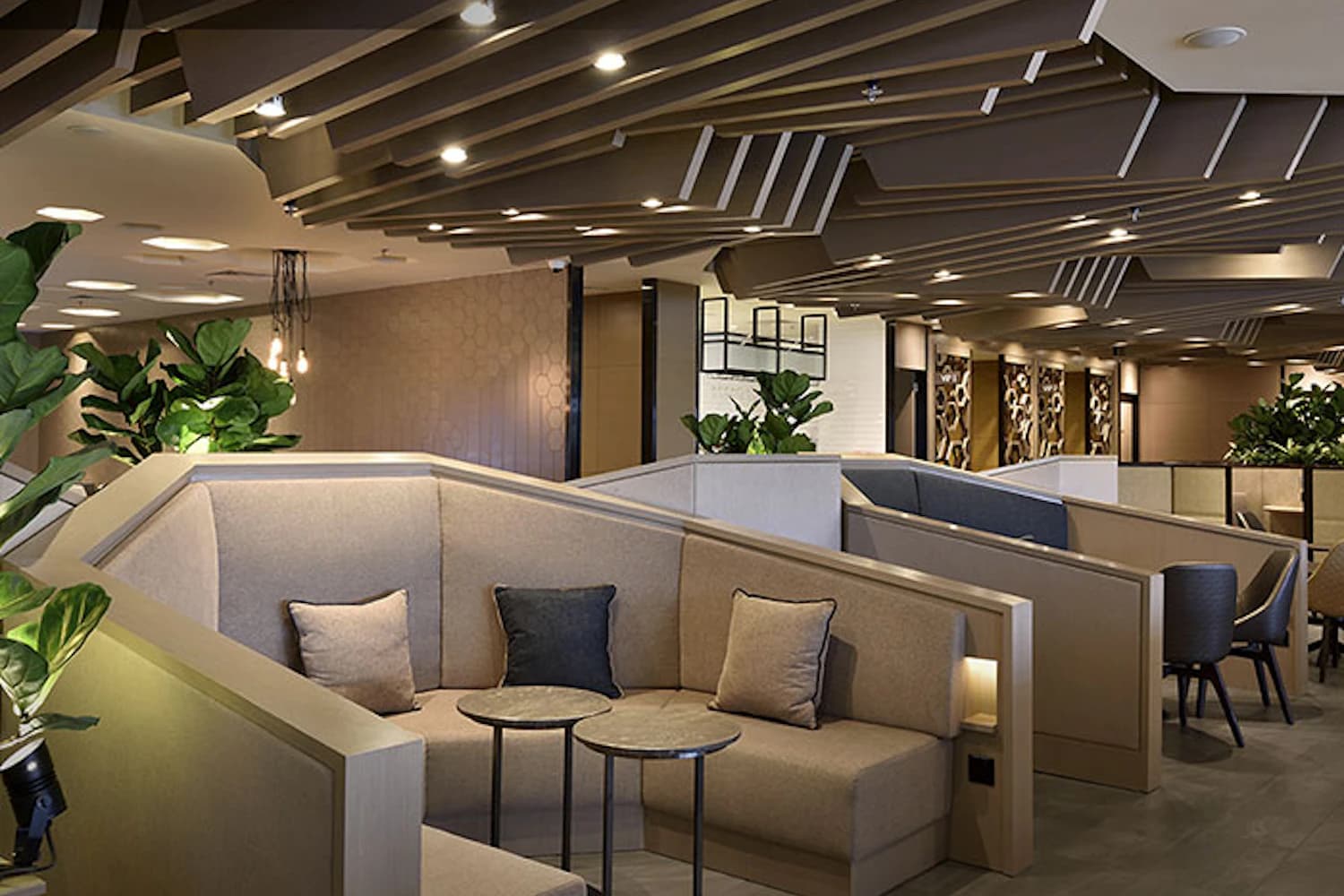 Abgeschirmte Sitznischen mit Kissen und Pflanzen in der Plaza Premium Lounge in Terminal 1 am Flughafen Singapur