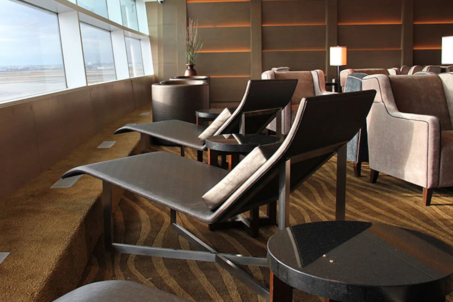 Zwei Liegen mit Kissen an der Fensterfront der Plaza Premium Lounge am Flughafen Toronto