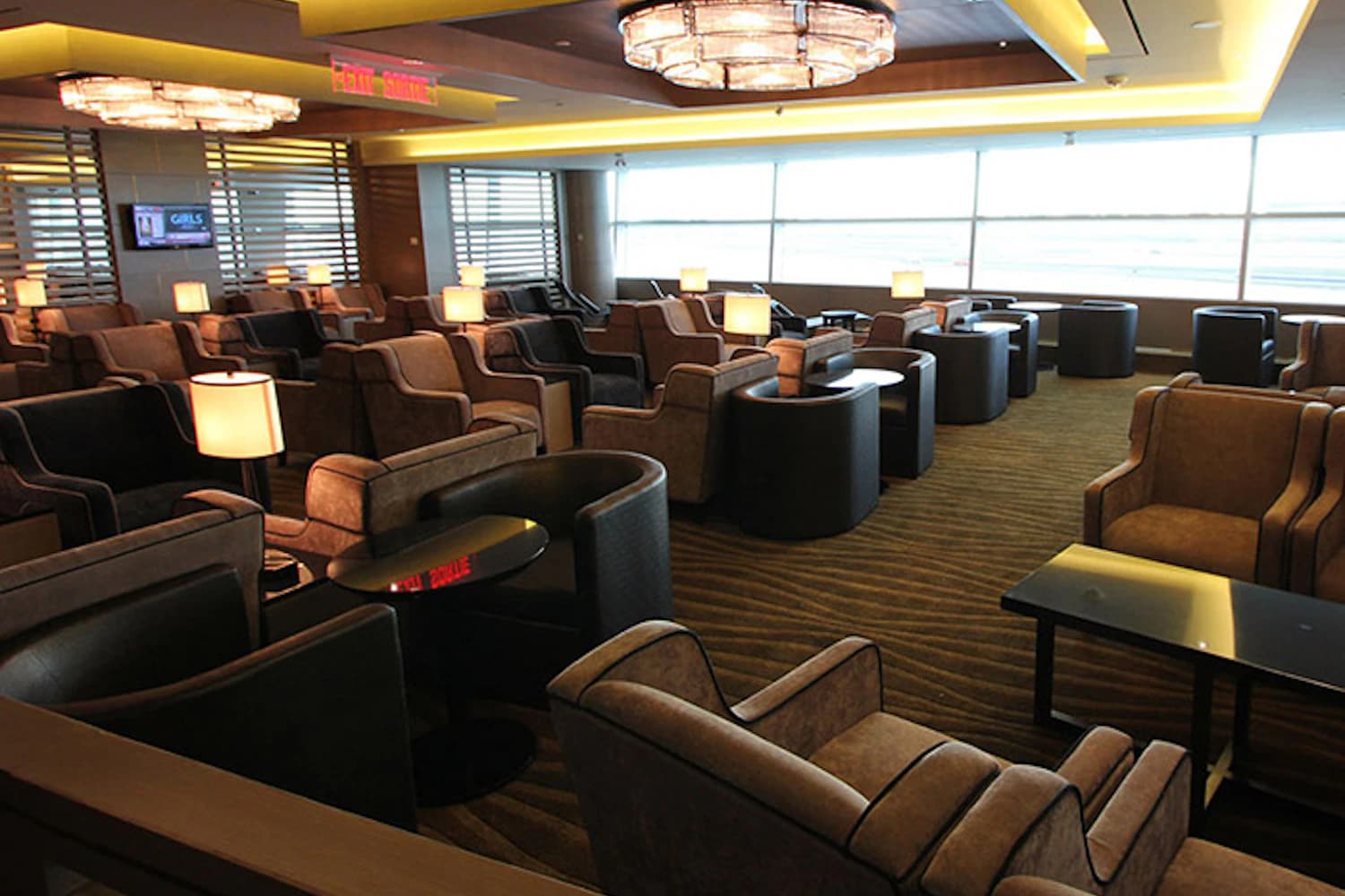 Ruhebereich mit Polstersesseln und Tischlampen in der Plaza Premium Lounge am Flughafen Toronto